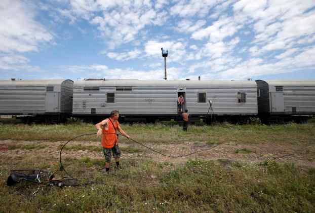 Railway employees are pictured as they work near refrigerator wagons, which according to employees and local residents contain bodies of passengers of the crashed Malaysia Airlines Boeing 777 plane, at a railway station in the town of Torez