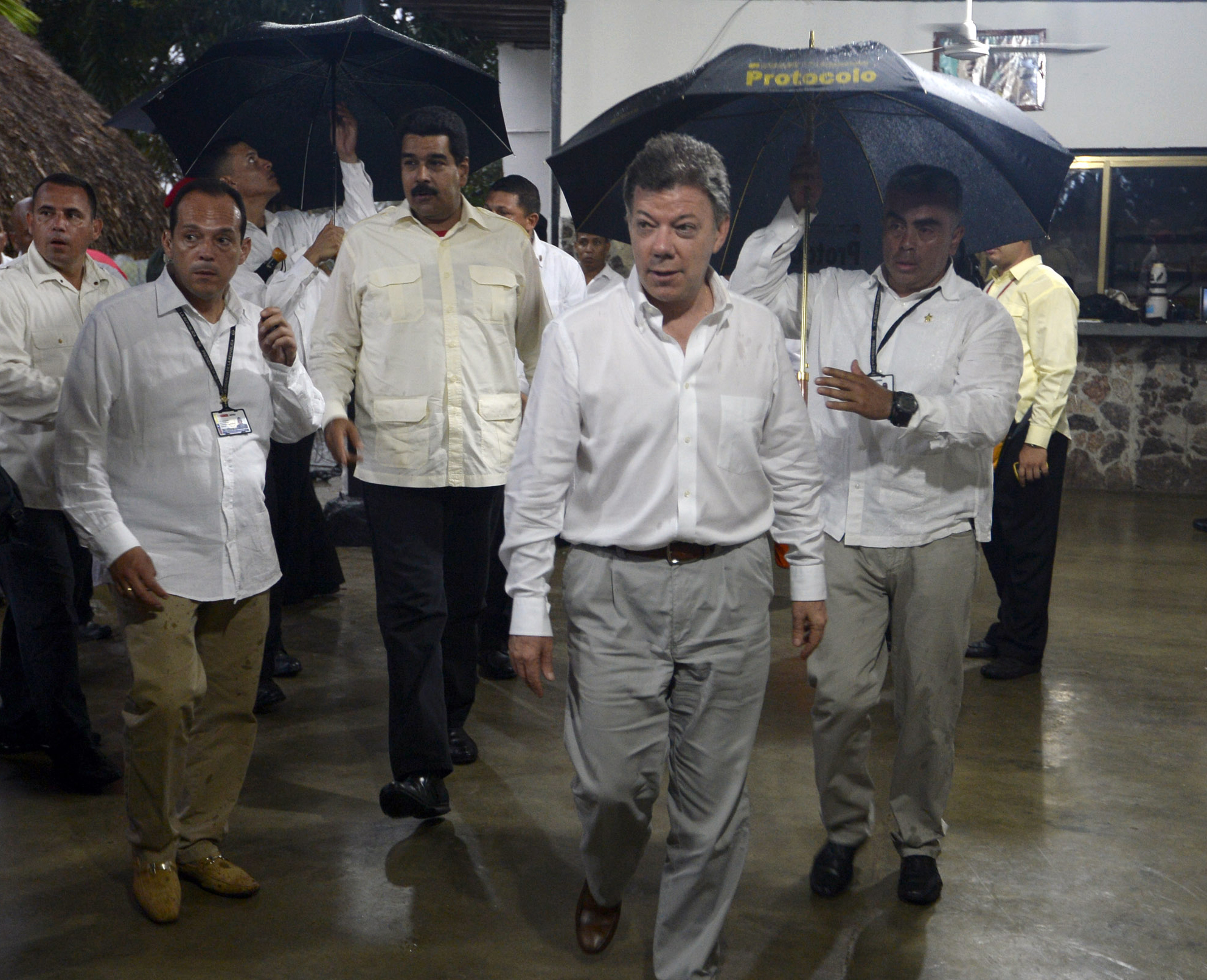 Así cubren a Santos y Maduro de la lluvia (Foto)