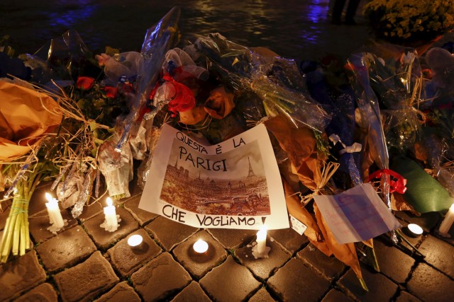 A placard reading "This is the Paris we want" is seen next to flowers placed for victims of the Paris attacks in front of the French embassy in Rome, Italy November 14, 2015. REUTERS/Remo Casilli