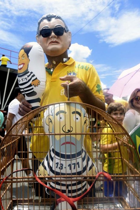 Demonstrators take part in a protest demanding President Dilma Rousseff's resignation on March 13, 2016 at the Esplanada dos Ministerios in Brasilia. Protesters, many draped in the Brazilian national flag, poured into the streets of Brasilia and Rio de Janeiro on Sunday at the start of mass demonstrations seeking to bring down President Dilma Rousseff.    AFP PHOTO / EVARISTO SA / AFP / EVARISTO SA