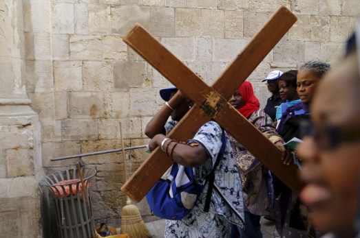 Worshippers carry a cross during a Good Friday procession through the Via Dolorosa in Jerusalem's Old City March 25, 2016. REUTERS/Ammar Awad