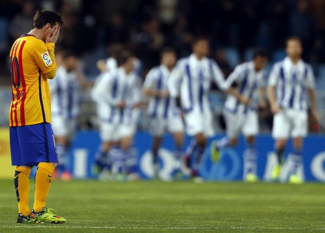 El delantero argentino del FC Barcelona Leo Messi (i) se lamenta tras recibir el primer gol de la Real Sociedad, en el estadio de Anoeta, de San Sebastián. EFE