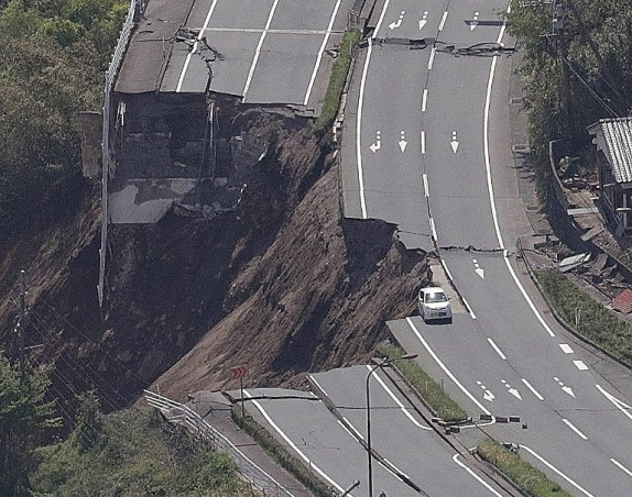 La vista aérea muestra una carretera colapsada después de un terremoto en Minami-Aso, en la prefectura de Kumamoto, el 16 de abril de 2016. Un potente terremoto de 7,0 grados sacudió el sur de Japón a tempranas horas del 16 de abril AFP PHOTO / JIJI PRESS / STR / Japan OUT
