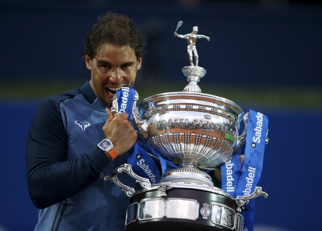Rafael Nadal of Spain bites the Barcelona Open trophy after defeating Kei Nishikori of Japan in Barcelona, Spain, April 24, 2016. REUTERS/Albert Gea      TPX IMAGES OF THE DAY
