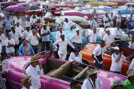 Conductores de autos estadounidenses clásicos reciben instrucciones finales sobre como traer a las modelos que participarían en el espectáculo de modas de Chanel, en el estacionamiento del Hotel Nacional, en La Habana, Cuba, el martes 3 de mayo de 2016. (Foto AP/Ramón Espinosa)