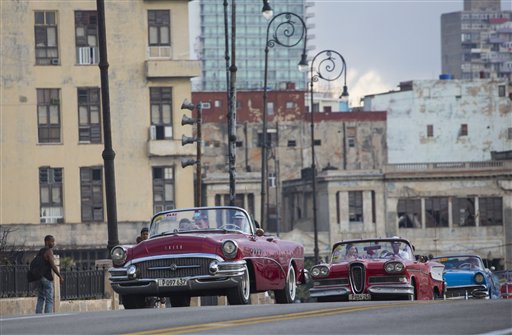 Varias modelos viajan en descapotables clásicos por el Malecón de La Habana para participar en el desfile de Chanel en La Habana, Cuba, el martes 3 de mayo de 2016. (AP Foto/Desmond Boylan)