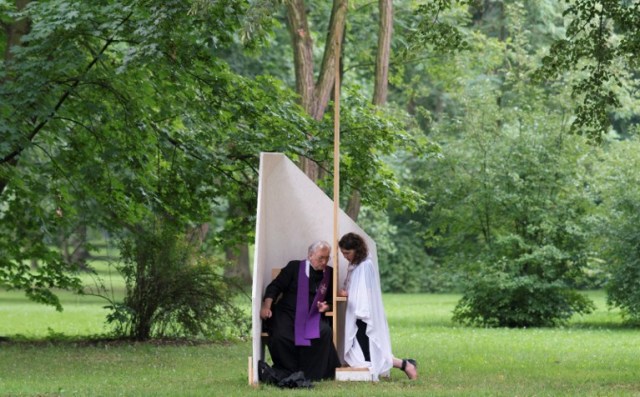 A priest listens to a confession on the Blonia Meadows in Krakow, on July 26, 2016, to celebrate the Opening Mass on the first day of the World Youth Days. Pope Francis heads to Poland on July 27 for an international Catholic youth festival with a mission to encourage openness to migrants made tougher by a fresh jihadist attack in France in which two jihadists attacked a church in a Normandy town, killing an elderly Catholic priest by slitting his throat, and severely injuring another person. / AFP PHOTO / JOE KLAMAR