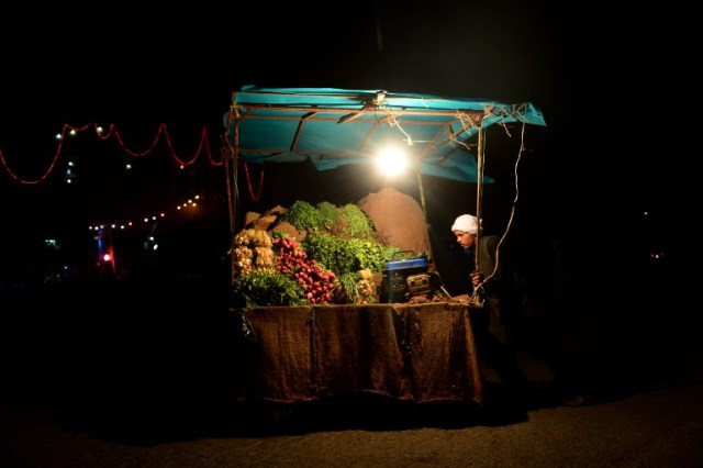 In this photograph taken on July 26, 2016, an Afghan fruit vendor waits for customers at a roadside stall in Herat. / AFP PHOTO / AREF KARIMI