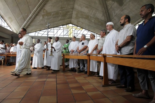 Muslim worshippers take part in a Sunday church service on July 31, 2016, in Nice, southeastern France. Muslims across France were invited to participate in Catholic Sunday service to mourn a priest whose murder by jihadist teenagers sparked fears of religious tension. Masses will be celebrated across the country in honour of octogenarian Father Jacques Hamel, whose throat was cut in his church on July 26, in the latest jihadist attack on France.   / AFP PHOTO / JEAN CHRISTOPHE MAGNENET