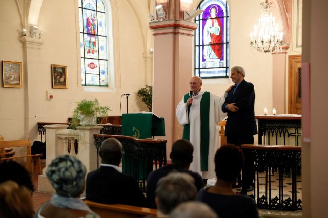 Bagnolet's priest Patrick Morvan (L) holds the shoulder of Bagnolet's Mosque's rector Mohamed Rakkaby (R) as he pronounces a speech to Christian and Muslim believers during a Mass in tribute to priest Jacques Hamel at the Saint-Leu ? Saint-Gilles Bagnolet's Church, near Paris, on July 31, 2016. Muslims across France were invited to participate in Catholic ceremonies today to mourn a priest whose murder by jihadist teenagers sparked fears of religious tension. Masses will be celebrated across the country in honour of octogenarian Father Jacques Hamel, whose throat was cut in his church on July 26, 2016 in the latest jihadist attack on France. / AFP PHOTO / Thomas SAMSON