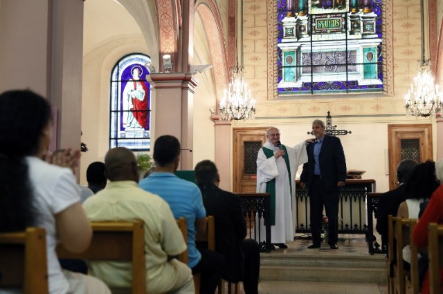 Bagnolet's priest Patrick Morvan (L) holds the shoulder of Bagnolet's Mosque's rector Mohamed Rakkaby (R) as he pronounces a speech to Christian and Muslim believers during a Mass in tribute to priest Jacques Hamel at the Saint-Leu ? Saint-Gilles Bagnolet's Church, near Paris, on July 31, 2016. Muslims across France were invited to participate in Catholic ceremonies today to mourn a priest whose murder by jihadist teenagers sparked fears of religious tension. Masses will be celebrated across the country in honour of octogenarian Father Jacques Hamel, whose throat was cut in his church on July 26, 2016 in the latest jihadist attack on France. / AFP PHOTO / THOMAS SAMSON