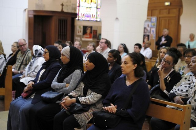 Muslim faithful sits as they attend a Mass in tribute to priest Jacques Hamel at the Saint-Leu ? Saint-Gilles Bagnolet's Church, near Paris, on July 31, 2016. Muslims across France were invited to participate in Catholic ceremonies today to mourn a priest whose murder by jihadist teenagers sparked fears of religious tension. Masses will be celebrated across the country in honour of octogenarian Father Jacques Hamel, whose throat was cut in his church on July 26, 2016 in the latest jihadist attack on France. / AFP PHOTO / THOMAS SAMSON