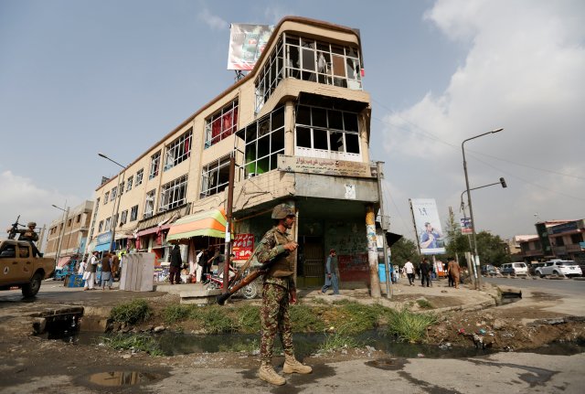 An Afghan security force personnel stands guard in front of a damaged building a day after a suicide attack in Kabul, Afghanistan July 24, 2016. REUTERS/Mohammad Ismail
