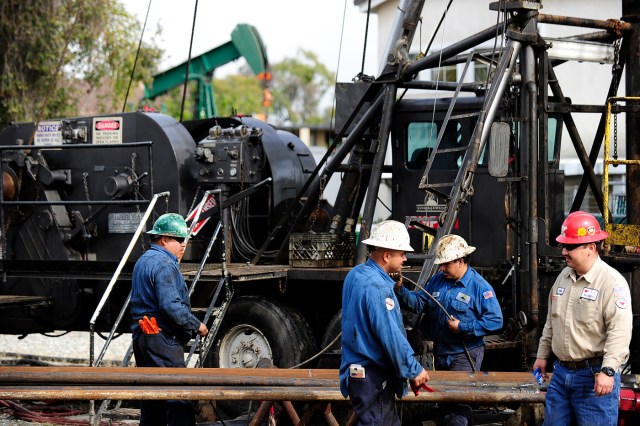 (FILES) This file photo taken on March 2, 2011 shows workers performing maintenance on a well owned by Signal Hill Petroleum in Signal Hill, California. US oil industry analysts were hopeful but still skeptical September 29, 2016 that OPEC would be able to boost oil prices with an agreement to limit output. After seeing the crash in oil prices force a cutback of US domestic production of more than one million barrels a day, the tentative OPEC pact could deliver some relief to US drillers. / AFP PHOTO / ROBYN BECK