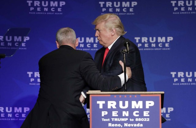 Agentes del Servicio Secreto se apresuran a retirar al candidato presidencial republicano, Donald Trump, del escenario durante un mitin en Reno, Nevada, el sábado 5 de noviembre de 2016. (AP Foto/John Locher)