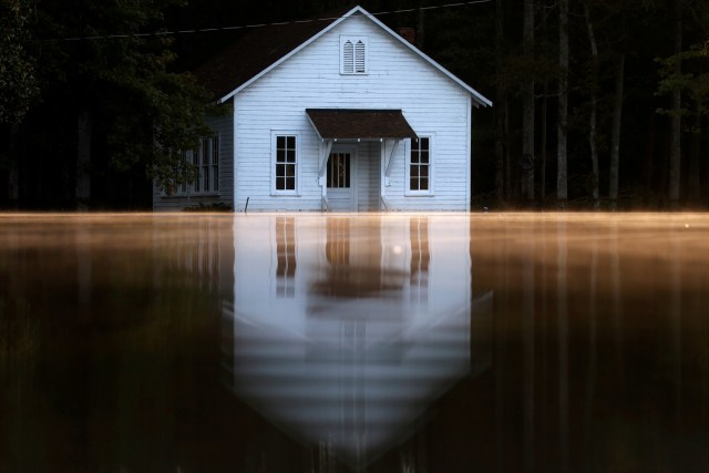 FILE PHOTO - Mist rises off the water as a flooded building is pictured after Hurricane Matthew passes in Lumberton, North Carolina, U.S., October 11, 2016. REUTERS/Carlo Allegri/File Photo REUTERS PICTURES OF THE YEAR 2016 - SEARCH 'POY 2016' TO FIND ALL IMAGES