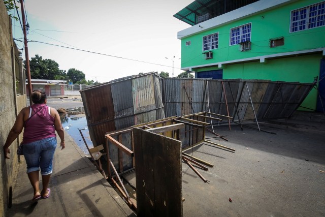 A woman walks on the street next to a makeshift barricade after a demonstration in Ciudad Bolivar, Venezuela December 19, 2016. REUTERS/William Urdaneta EDITORIAL USE ONLY. NO RESALES. NO ARCHIVE.