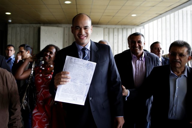 Hector Rodriguez, deputy of Venezuela's United Socialist Party (PSUV), shows a document as he leaves the Supreme Court after challenging the National Assembly, in Caracas, Venezuela January 10, 2017. REUTERS/Marco Bello