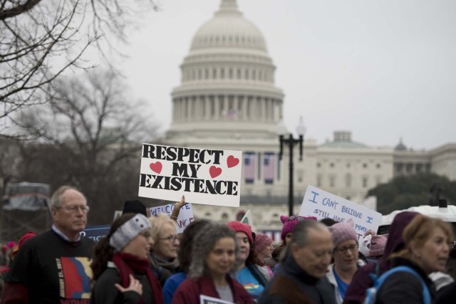 Demonstrators march past the US Capitol during the Women's March on Washington in Washington, DC, January 21, 2017. Hundreds of thousands of protesters spearheaded by women's rights groups demonstrated across the US to send a defiant message to US President Donald Trump. / AFP PHOTO / JIM WATSON