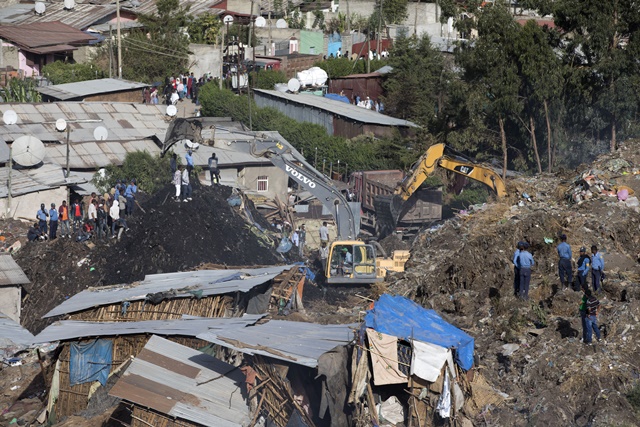 Excavators move earth as rescuers work at the site of a landslide at the main landfill of Addis Ababa on the outskirts of the city on March 12, 2017. At least 30 people died and dozens more were hurt in a giant landslide at Ethiopia's largest rubbish dump outside Addis Ababa, a tragedy squatters living there blamed on a biogas plant being built nearby. The landslide late on March 11 saw dozens of homes of people living in the dump levelled after a part of the largest pile of rubbish at the Koshe landfill collapsed, an AFP journalist said. / AFP PHOTO / ZACHARIAS ABUBEKER