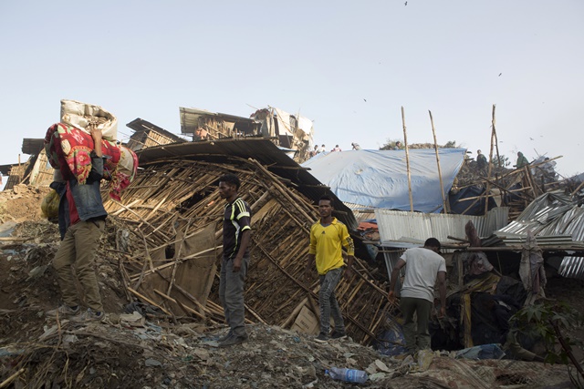 People move their belongings on March 12, 2017 after dwellings built near the main landfill of Addis Ababa on the outskirts of the city were damaged in a landslide that left at least 30 people dead. At least 30 people died and dozens more were hurt in a giant landslide at Ethiopia's largest rubbish dump outside Addis Ababa, a tragedy squatters living there blamed on a biogas plant being built nearby. The landslide late on March 11 saw dozens of homes of people living in the dump levelled after a part of the largest pile of rubbish at the Koshe landfill collapsed, an AFP journalist said. / AFP PHOTO / ZACHARIAS ABUBEKER