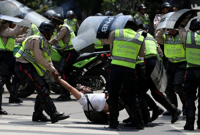 A demonstrator is arrested by riot police while rallying against Venezuela's President Nicolas Maduro's government in Caracas