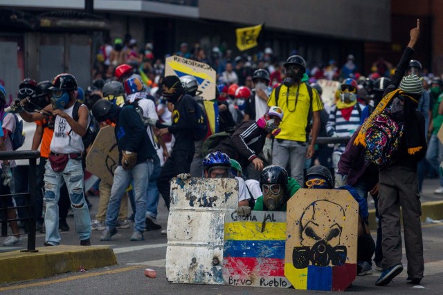 CAR139. CARACAS (VENEZUELA), 20/05/2017.- Manifestantes opositores se enfrentan a la Policía Nacional Bolivariana hoy, sábado 20 de mayo de 2017, en Caracas (Venezuela). Las fuerzas de seguridad de Venezuela dispersaron hoy con gases lacrimógenos una marcha opositora que pretendía movilizarse desde el este de Caracas hasta la sede del Ministerio de Interior, en el centro de la ciudad, órgano al que los opositores responsabilizan de la "represión" en las protestas. EFE/CRISTIAN HERNÁNDEZ