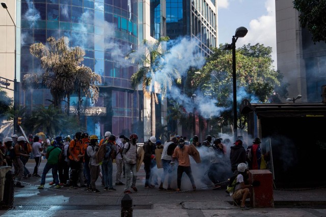 CAR150. CARACAS (VENEZUELA), 20/05/2017.- Manifestantes opositores se enfrentan a la Policía Nacional Bolivariana hoy, sábado 20 de mayo de 2017, en Caracas (Venezuela). Las fuerzas de seguridad de Venezuela dispersaron hoy con gases lacrimógenos una marcha opositora que pretendía movilizarse desde el este de Caracas hasta la sede del Ministerio de Interior, en el centro de la ciudad, órgano al que los opositores responsabilizan de la "represión" en las protestas. EFE/MIGUEL GUTIÉRREZ