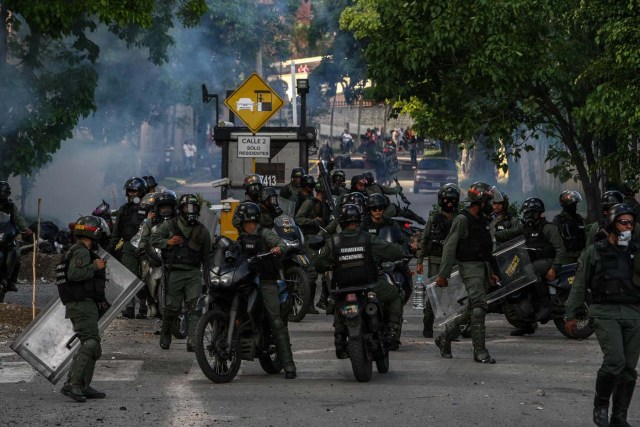 CAR06. CARACAS (VENEZUELA), 14/06/2017.- Miembros de la Guardia Nacional Bolivariana (GNB) se enfrenta a un grupo de manifestantes hoy, miércoles 14 de junio de 2017, en Caracas (Venezuela). Una concentración de venezolanos opositores al Gobierno de Nicolás Maduro se disolvió hoy en la localidad de Altamira del municipio Chacao, considerado un bastión del antichavismo, luego de que se efectuaran varios disparos en el sitio, constató Efe. EFE/CRISTIAN HERNÁNDEZ
