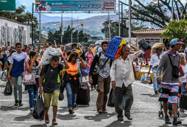 Venezuelan citizens cross the Simon Bolivar international bridge from San Antonio del Tachira, Venezuela to Cucuta, Norte de Santander Department, Colombia, on July 25, 2017. Some 25.000 Venezuelans cross to Colombia and return to their country daily with food, consumables and money from ilegal work, according to official sources. Also, there are 47.000 Venezuelans in Colombia with legal migratory status and another 150.000 who have already completed the 90 allowed days and are now without visa.  / AFP PHOTO / Luis Acosta