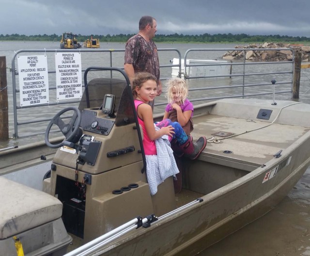 Mike Magee, 37, stands next to his boat with his daughters inside, before setting out on a mission to rescue a friend and her four children from heavy rains caused by Hurricane Harvey on Agust 28, 2017, near Hamshire, Texas. Monday was supposed to be the first day back at school. Instead the Magee daughters boarded a boat with their parents and floated down a Texas Interstate to rescue friends from dangerously rising flood water. "Aint nothing different than us going out on the river," mused Alissa Magee, 34, and she and husband Mike, 37, ferried Carol Brown and her four children to higher ground in Hamshire, Texas. / AFP PHOTO / Jennie MATTHEW / TO GO WITH AFP STORY by Jennie MATTHEW, "Family affair: boats to the rescue on Texas Interstate"