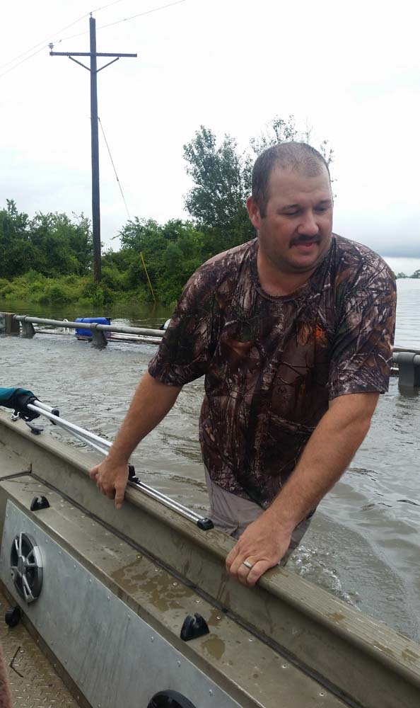 Mike Magee manoeuvres his boat on the way to rescue friends from flooding near Hamshire, Texas, on August 28, 2017. Monday was supposed to be the first day back at school. Instead the Magee daughters boarded a boat with their parents and floated down a Texas Interstate to rescue friends from dangerously rising flood water. "Aint nothing different than us going out on the river," mused Alissa Magee, 34, and she and husband Mike, 37, ferried Carol Brown and her four children to higher ground in Hamshire, Texas. / AFP PHOTO / Jennie MATTHEW / TO GO WITH AFP STORY by Jennie MATTHEW, "Family affair: boats to the rescue on Texas Interstate"