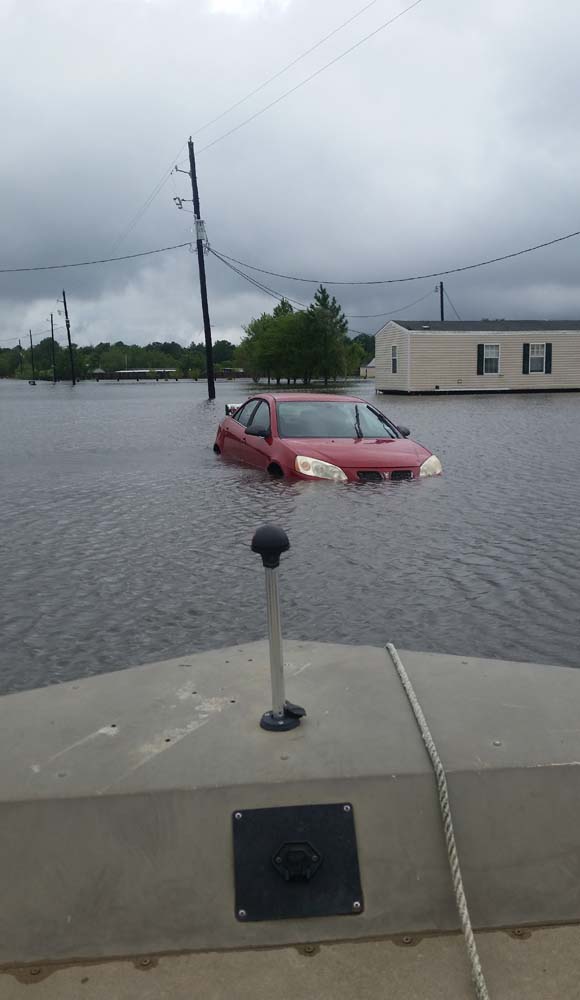 An abandoned car is shown submerged in flood water caused by super storm Harvey near Hamshire, Texas, on August 28, 2017. Monday was supposed to be the first day back at school. Instead the Magee daughters boarded a boat with their parents and floated down a Texas Interstate to rescue friends from dangerously rising flood water. "Aint nothing different than us going out on the river," mused Alissa Magee, 34, and she and husband Mike, 37, ferried Carol Brown and her four children to higher ground in Hamshire, Texas. / AFP PHOTO / Jennie MATTHEW / TO GO WITH AFP STORY by Jennie MATTHEW, "Family affair: boats to the rescue on Texas Interstate"
