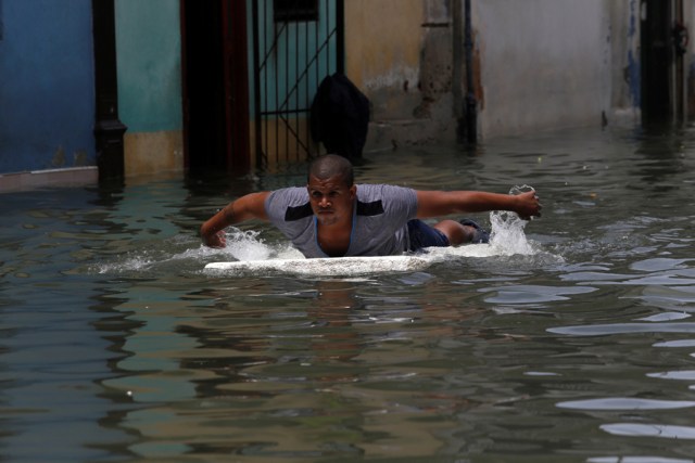 A man uses a piece of foam board to get through a flooded street, after the passing of Hurricane Irma, in Havana, Cuba September 10, 2017. REUTERS/Stringer NO SALES. NO ARCHIVES