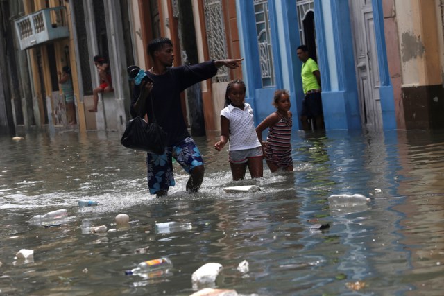 A man and two children wade through a flooded street,  after the passing of Hurricane Irma, in Havana, Cuba September 10, 2017. REUTERS/Stringer NO SALES. NO ARCHIVES