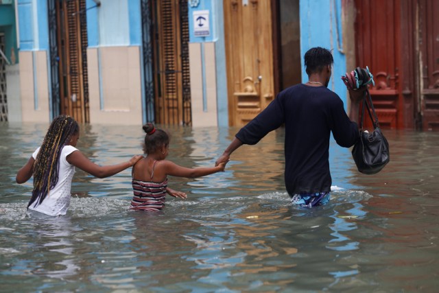 A man and two children wade through a flooded street,  after the passing of Hurricane Irma, in Havana, Cuba September 10, 2017. REUTERS/Stringer NO SALES. NO ARCHIVES