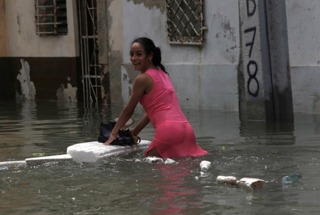 A woman keeps her shoes dry on a piece of foam board while wading through a flooded street, after the passing of Hurricane Irma, in Havana, Cuba September 10, 2017. REUTERS/Stringer NO SALES. NO ARCHIVES