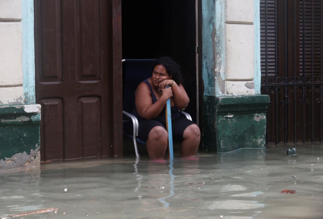 A woman sits in the door of her flooded home, after the passing of Hurricane Irma, in Havana, Cuba September 10, 2017. REUTERS/Stringer NO SALES. NO ARCHIVES