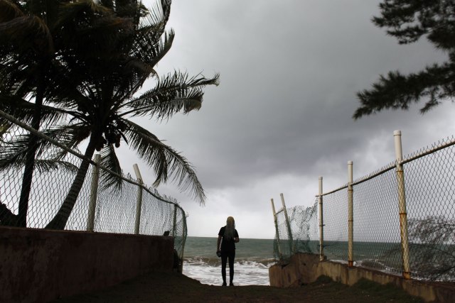  woman looks at heavy surf as Hurricane Irma approaches Puerto Rico in Luquillo, on September 6, 2017. Irma is expected to reach the Virgin Islands and Puerto Rico by nightfall on September 6. 