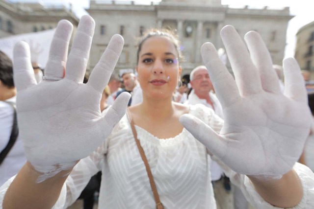 A woman shows her white painted hands duing a demonstration in favour of dialogue in a square in Barcelona, Spain, October 7, 2017 REUTERS/Eric Gaillard