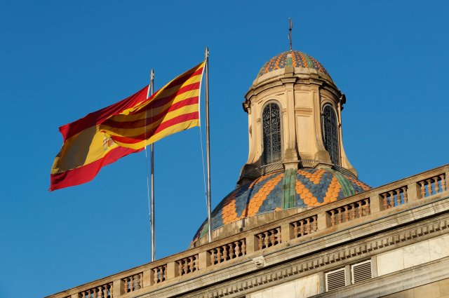 Las banderas españolas (L) y catalana ondean sobre el Palacio de la Generalitat, la sede del gobierno regional catalán en Barcelona, España, el 30 de octubre de 2017. REUTERS / Yves Herman
