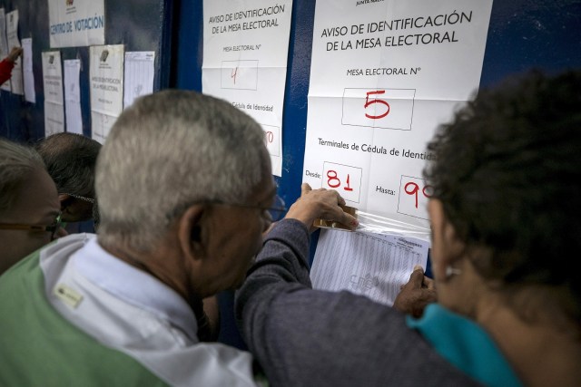 Varias personas asisten a un centro de votación hoy, 15 de octubre de 2017, en Caracas (Venezuela). Los centros de votación en Venezuela comenzaron hoy a abrir sus puertas a las seis de la mañana hora local (10.00 GMT), como estaba previsto, para atender a los ciudadanos que están llamados a participar en la elección de los 23 gobernadores del país caribeño. EFE/Miguel Gutiérrez