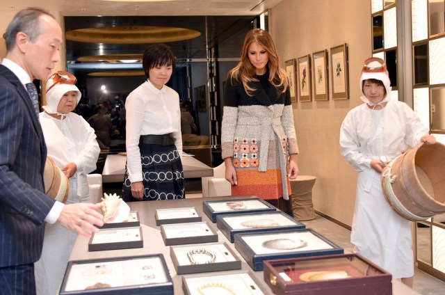 U.S. first lady Melania Trump listens to explanations by Hajime Fukuju (L), sales manager of Mikimoto, alongside Japan's first lady Akie Abe and Ama divers, during her visit to Mikimoto Pearl head shop in Tokyo's Ginza district, Japan, November.5, 2017.  REUTERS/Katsumi Kasahara/Pool