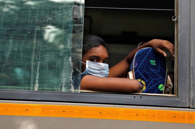 A girl wearing a face mask looks out from a bus on a smoggy day in New Delhi, India, November 13, 2017. REUTERS/Saumya Khandelwal