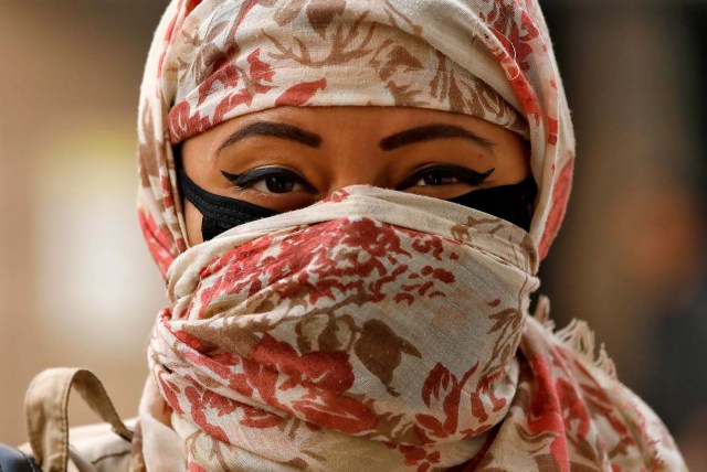 A woman walks with her face covered with a scarf and a face mask on a smoggy day in New Delhi, India, November 13 2017. REUTERS/Saumya Khandelwal