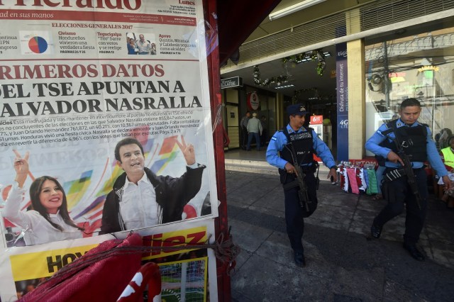 The front page of a local newspaper shows Honduran opposition candidate Salvador Nasralla and his wife Iroshka Elvir, at a stand in Tegucigalpa on November 27, 2017, a day after the general election. Initial election results released early Monday in Honduras showed opposition candidate Salvador Nasralla leading President Juan Orlando Hernandez, after a tense evening that saw both men declare themselves the winner before official numbers were announced. / AFP PHOTO / Rodrigo ARANGUA