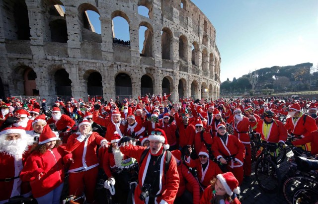 More than a hundred cyclists dressed as Santa Claus meet at the Colosseum in Rome, Italy December 17, 2017. REUTERS/Tony Gentile