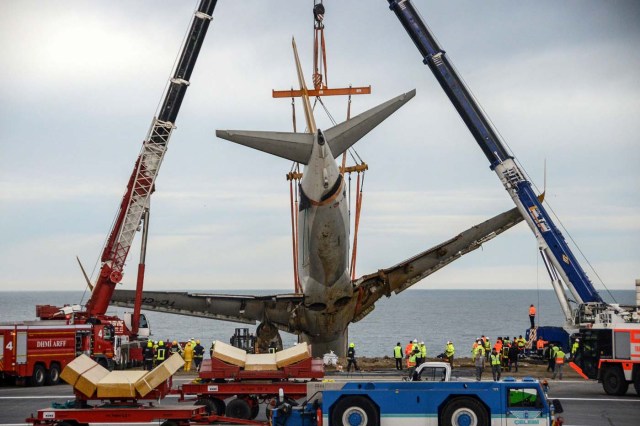 A photo made available by the Dogan News Agency shows the Pegasus Turkish passenger plane being lifted by cranes on January 18, 2018, five days after it skidded off the runway just metres away from the sea as it landed at Trabzon's airport in northern Turkey. / AFP PHOTO / DOGAN NEWS AGENCY / - / Turkey OUT