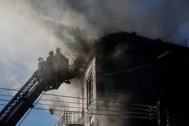 Fire Department of New York (FDNY) firemen work at an apartment building in the Bronx, New York, U.S., January 2, 2018. REUTERS/Shannon Stapleton