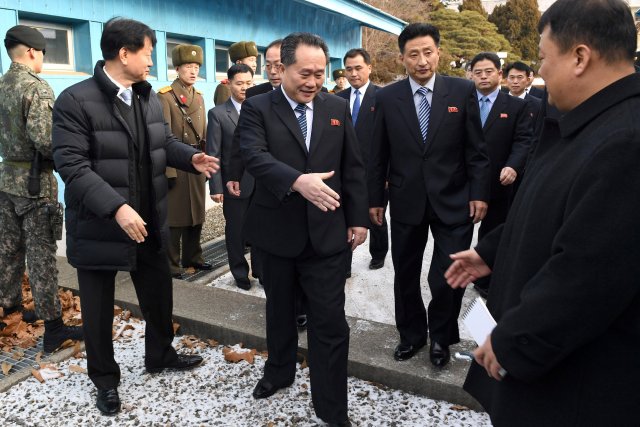 Head of North Korean delegation Ri Son Gwon, Chairman of the Committee for the Peaceful Reunification of the Country (CPRC) of DPRK, reaches out to shake hands with a South Korean official as he crosses a concrete border to attend their meeting at the truce village of Panmunjom in the demilitarised zone separating the two Koreas, South Korea, January 9, 2018. REUTERS/Korea Pool